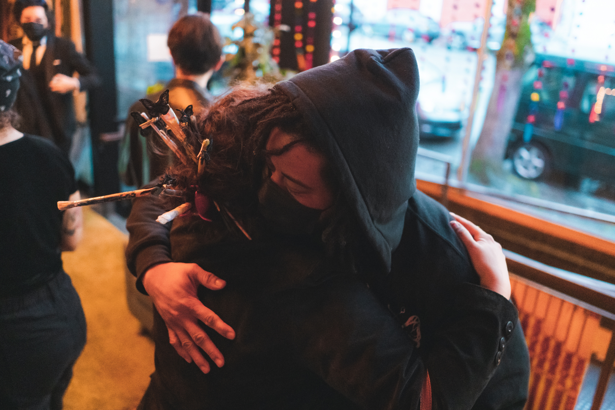 Two people embracing in a hub in the lobby of a building.